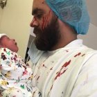 Jad, lleno de sangre debido a los efectos de la explosión, sujeta a su hijo Nabil, que no sufrió ni un rasguño / Fotos- ACN