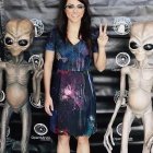 Una visitante del International Ufo Congress -que se celebra desde 1991- se fotografía con dos muñecos