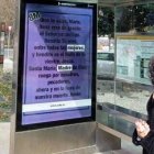 Una mujer mira el Avemaría en las marquesinas de la campaña La Mejor Mujer