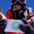 Abraham Tagit Sorang mostrando la bandera de la Asociación Católica de Arunachal Pradesh