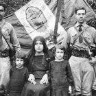 Familia cristera junto a la bandera mexicana y guadalupana, prestos al combate por Cristo Rey.