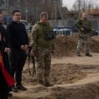 El arzobispo Shevchuk, con dos asistentes y militares ucranianos, ante la fosa común de Bucha el 7 de abril