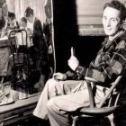 Norman Rockwell, en su estudio ante uno de sus cuadros de estampas familiares.