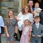 Jeremy, su esposa Carly, sus 7 hijos y el párroco de Santa Rita en Alexandria