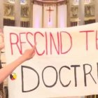 En la misa del Papa Francisco en Quebec 4 activistas desplegaron la pancarta Rescindir la doctrina... llamada del descubrimiento