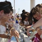 Peregrinos acalorados consiguen lavarse en uno de los escasos puntos de agua en el Parque del Tajo en la JMJ de Lisboa