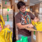 Jóvenes voluntarios de la JMJ de Lisboa preparan las mochilas con el kit del peregrino