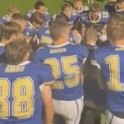 Una escena del vídeo que se viralizó, que muestra a los integrantes del equipo colegial de fútbol americano rodilla en tierra, rezando un avemaría antes del partido, según es su costumbre.