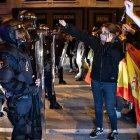 Unos jóvenes exhiben sus rosarios ante la Policía durante las manifestaciones ante la sede del PSOE en Madrid, en la calle Ferraz.