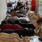 Migrantes durmiendo en el suelo en la zona internacional del aeropuerto de Barajas en febrero