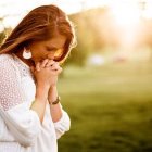 Una mujer en oración, en un campo luminoso, símbolo de esperanza