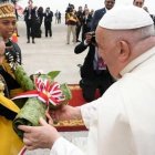 Unos niños con trajes típicos indonesios entregan flores al Papa Francisco a su llegada al aeropuerto de Yakarta