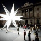 Al nacimiento le sustituye una estrella de luz de 20 puntas, cada una de cuatro metros de largo, que se llama Origen y ha sido pactada por las dos instituciones que se asoman a la plaza.