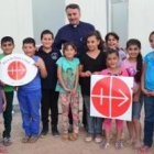 Niños de Irak con el logotipo de Ayuda a la Iglesia Necesitada, que mantiene decenas de proyectos allí y en Siria