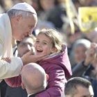 El Papa saluda a una niña en la audiencia del miércoles, que con el buen tiempo atrae a más gente