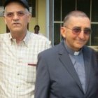 El padre Aldo Marchesini, vetsido con clérguiman y acompañado de unos colaboradores