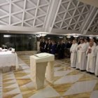 Francisco besa el altar al iniciarse la misa en la Residencia Santa Marta