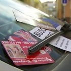 Imagen de un coche de Madrid, con varios de estos anuncios en el parabrisas