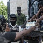 Mujer haitiana recogiendo alimentos de primera necesidad entregados por Cáritas.