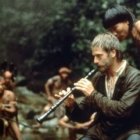 Con su oboe, el padre Gabriel atrae a los guaraníes y funda una misión en La Misión, película de 1986