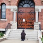 Una mujer reza ante la parroquia de Santa Teresa de Calcuta, en Dorchester, Boston, EEUU, cerrada por la pandemia, en 2020