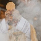 Un sacerdote eleva la Sagrada Forma en la consagración.