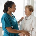 Una doctora acompaña a una paciente mayor