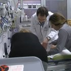 Un médico y otra persona atienden a un paciente en el hospital.