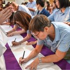 Catecúmenos en la parroquia de la Sagrada Familia de Singapur firman en los Ritos de Elección en la Cuaresma de 2025, para ser bautizados