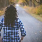Una chica andando por la carretera.