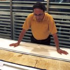 Roitman, gran experto en los manuscritos del Mar Muerto, examina uno de los rollos que se exhiben en Jerusalén