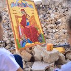 Unas niñas cristianas contemplan un icono de la Virgen entre las ruinas de Alepo (Siria).