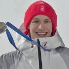 Kacper Tomasiak muestra la medalla de plata ganada en salto de trampolín normal individual.