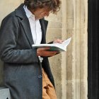 Un hombre fascinado con un libro, hasta olvida su café