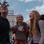 Jóvenes mochileros alzan la mirada en la Puerta del Sol en Madrid, en el vídeo de bienvenida a León XIV