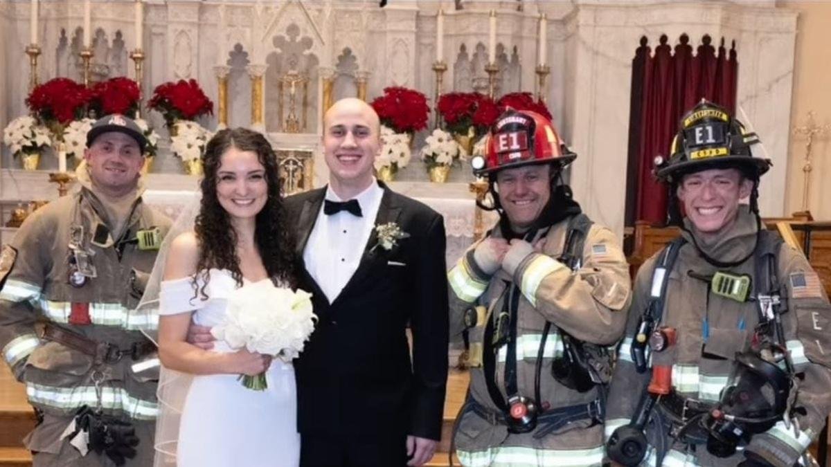 Eva y Daniel, tras casarse, rodeados de los bomberos que les ayudaron ante la alarma de incendios en una boda viral y considerada memorable.