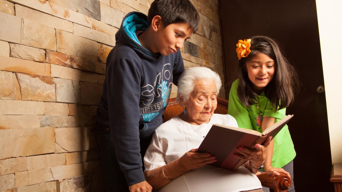 Una abuelita leyendo un libro a sus nietos