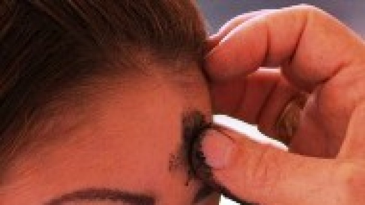 Una jóven recibe la ceniza de la conversión