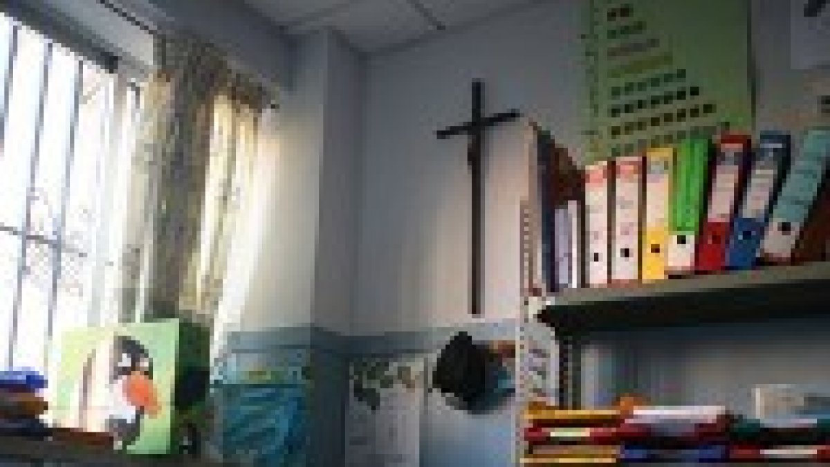 Un aula escolar con un Crucifijo