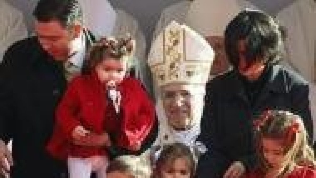 Rouco y una familia en la Misa de la Sagrada Familia