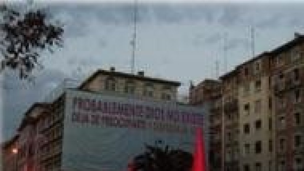 Una procesión religiosa con un cartel ofensivo a Dios al fondo