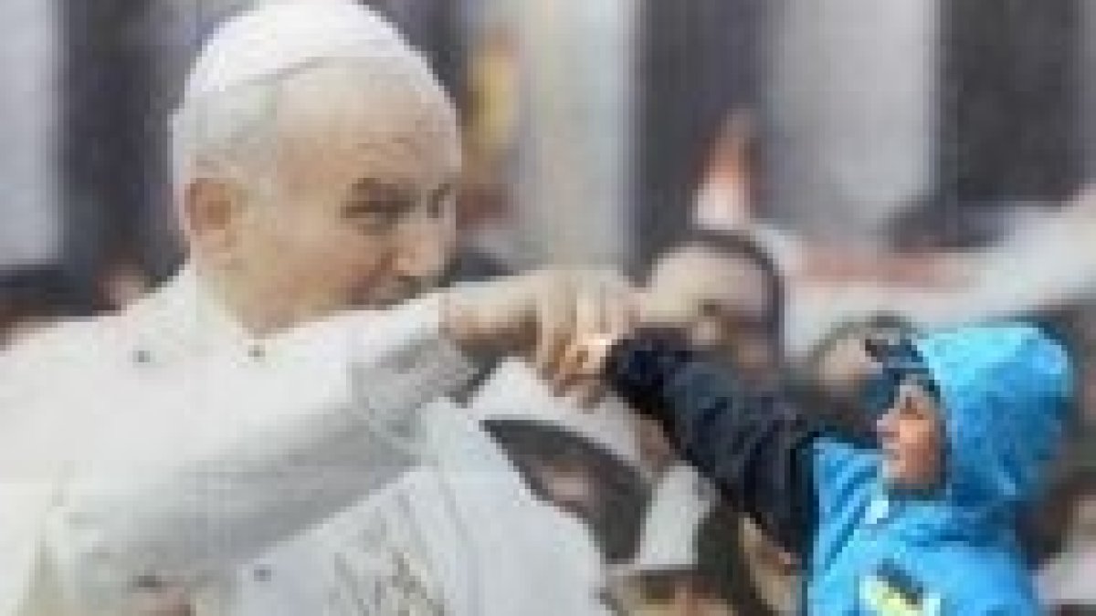 Un niño junto a una foto de JPII en Cracovia