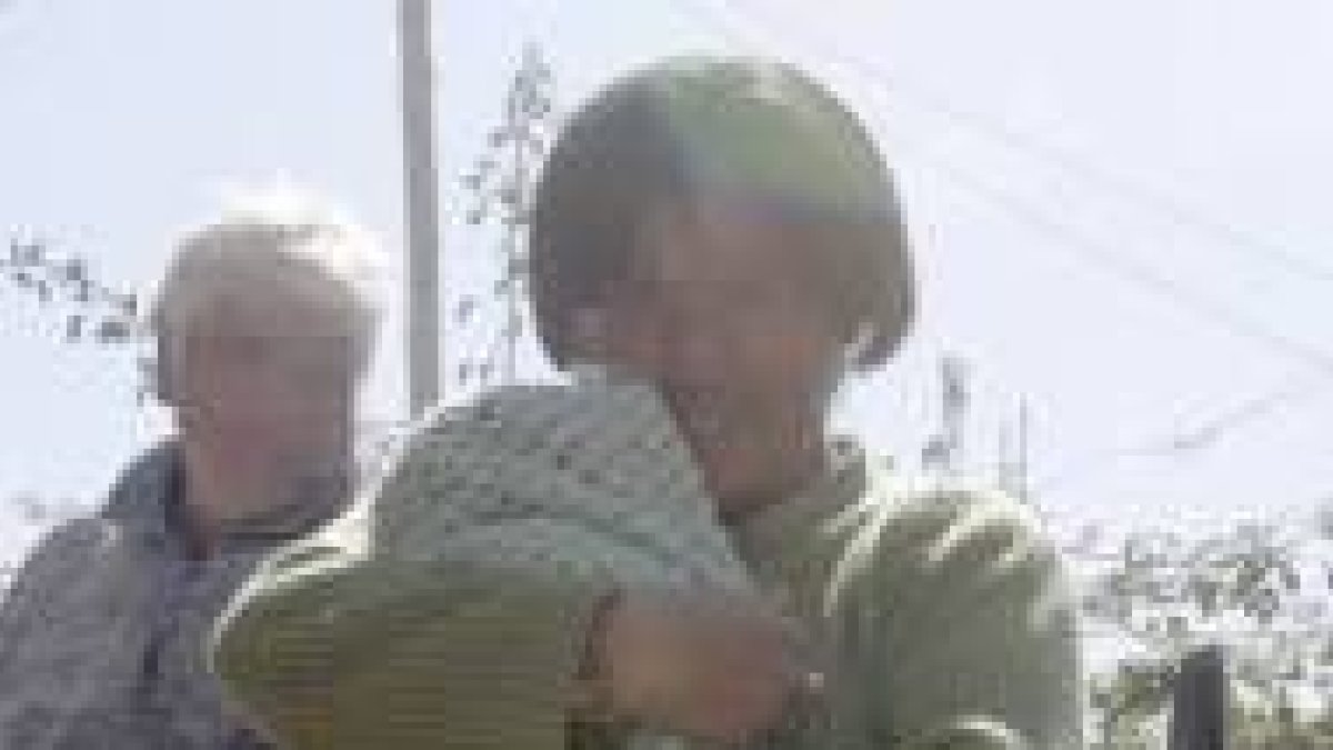 La mamá con el niño en brazos