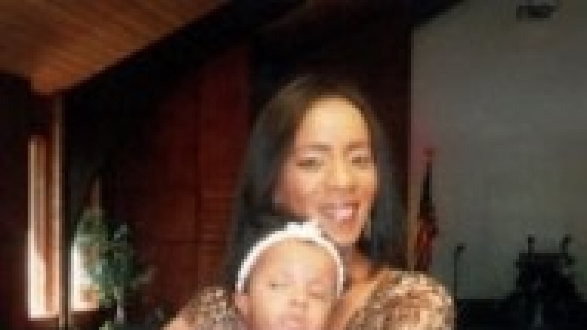 La mamá sostiene en brazos a su hija