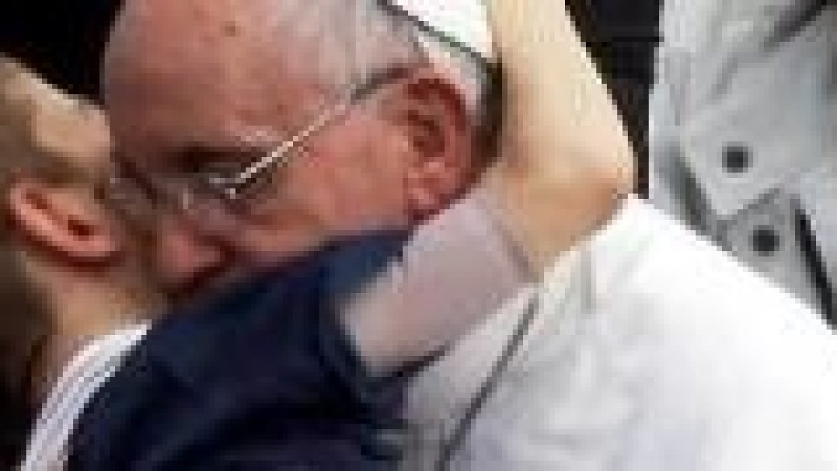 Francisco abraza a un niño