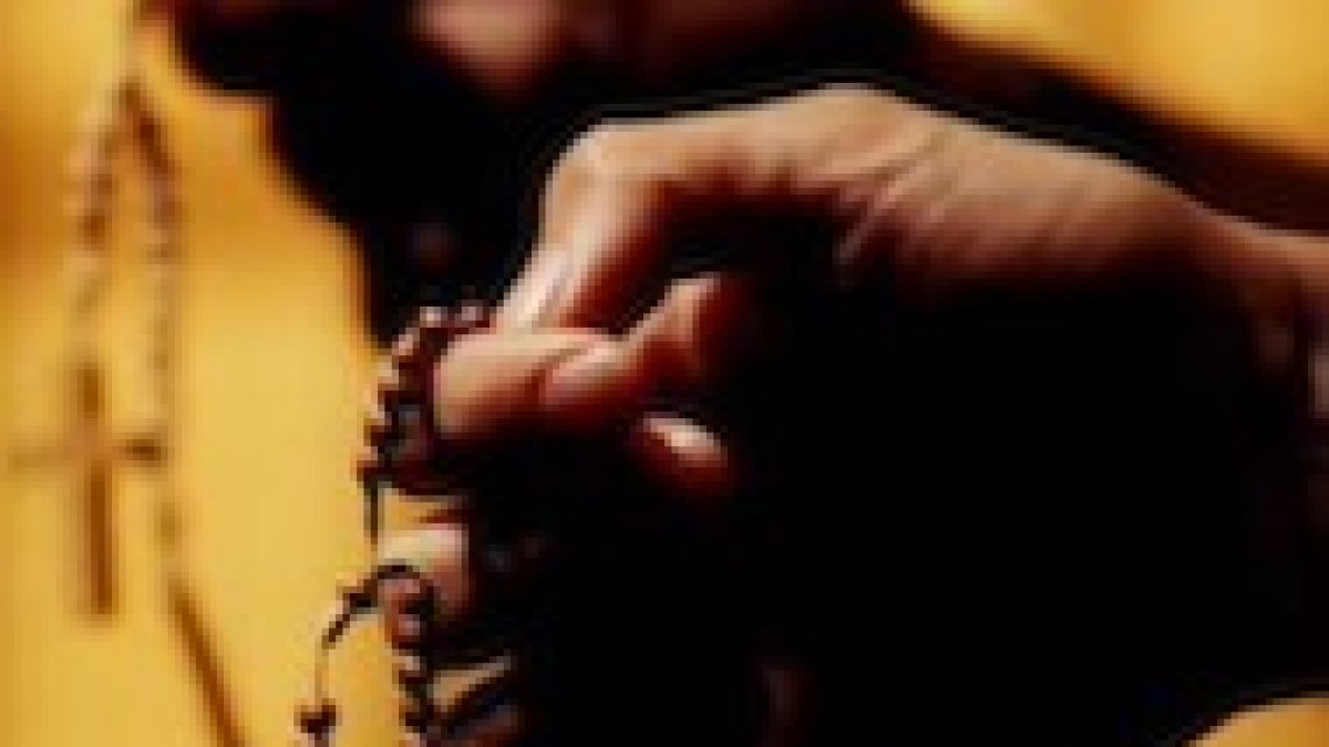 Una mujer sujeta un Rosario
