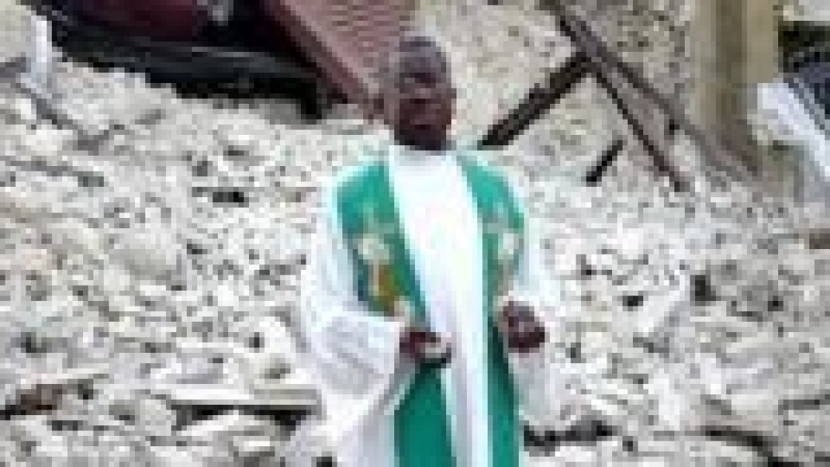 El padre Kenel, de Haití, ante las ruinas de la parroquia de San Luis