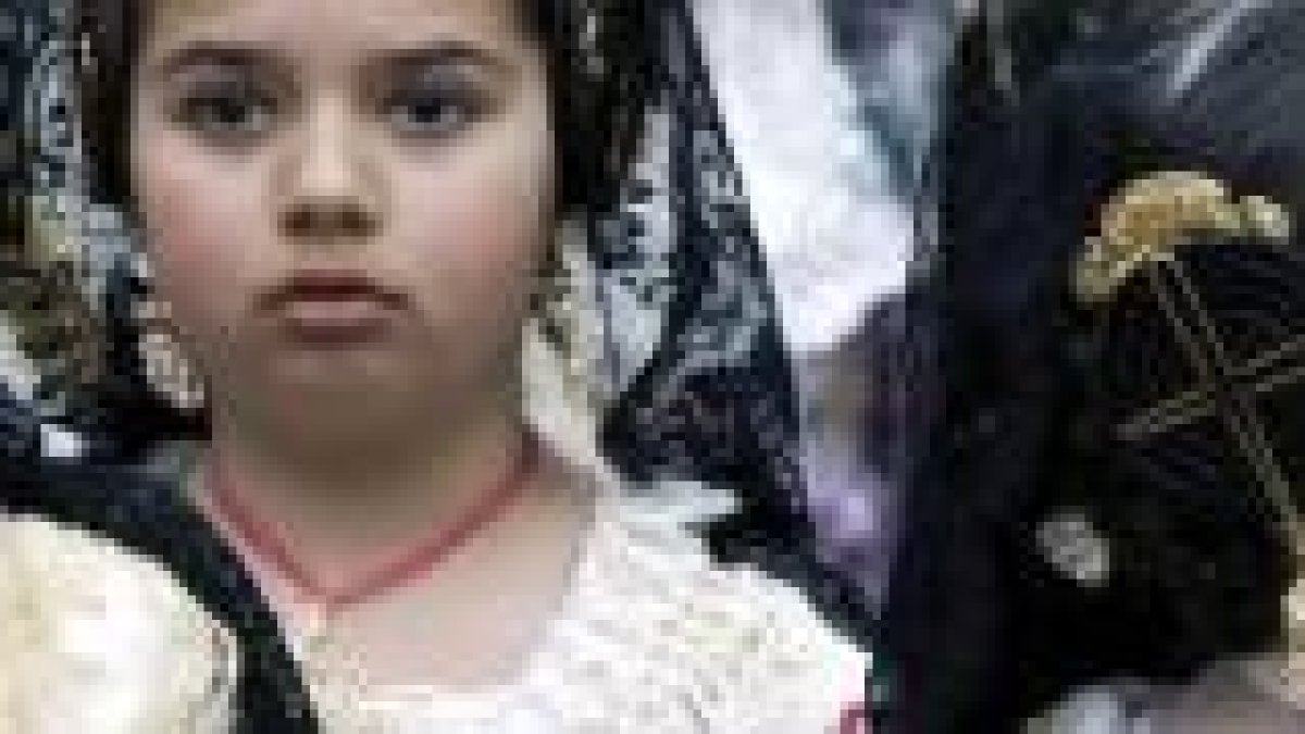 Pequeñas falleras llevan flores a la Virgen