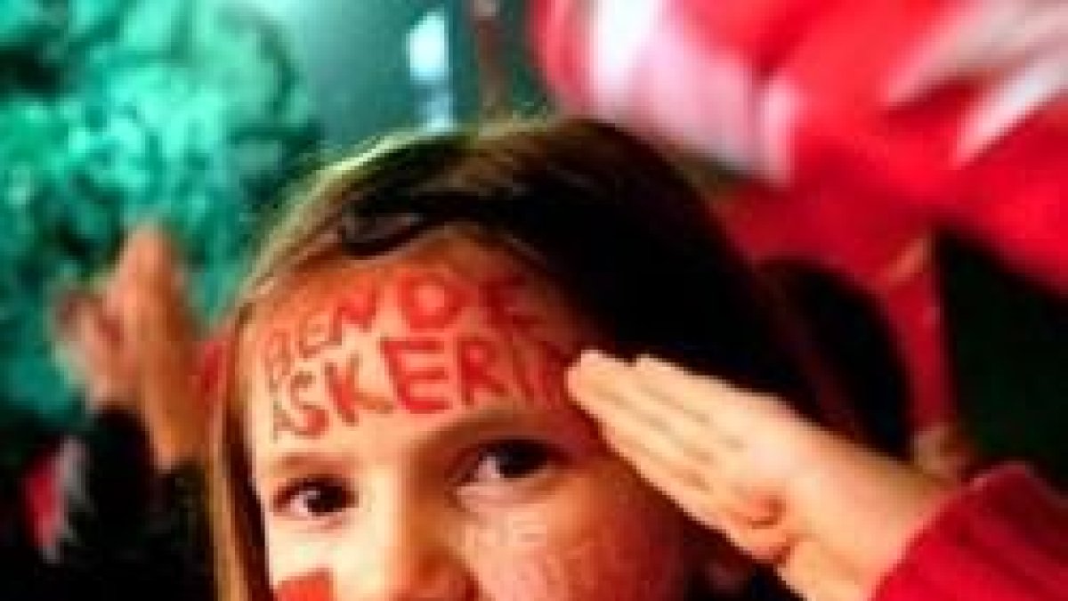 Una niña pintada con colores, banderas y lemas de la nación turca