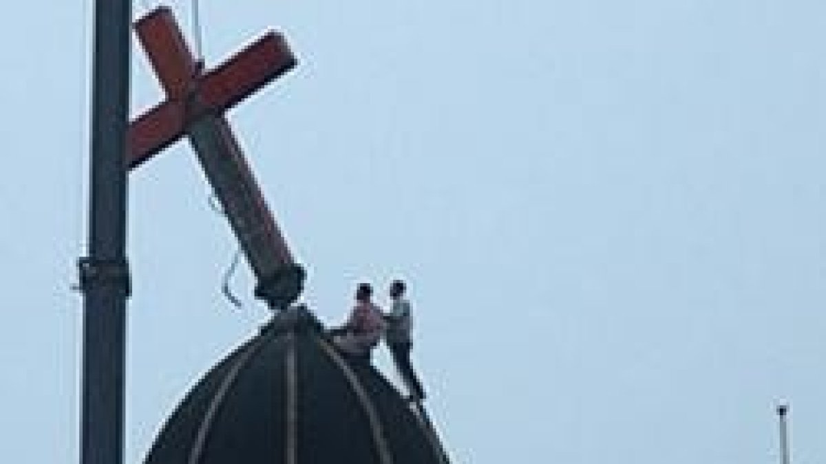 Unos operarios y una grúa retiran una cruz de una iglesia de Wenzhou por orden gubernamental